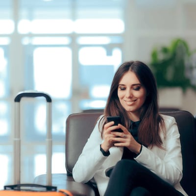 A business traveler relaxes on her phone in a hotel lobby