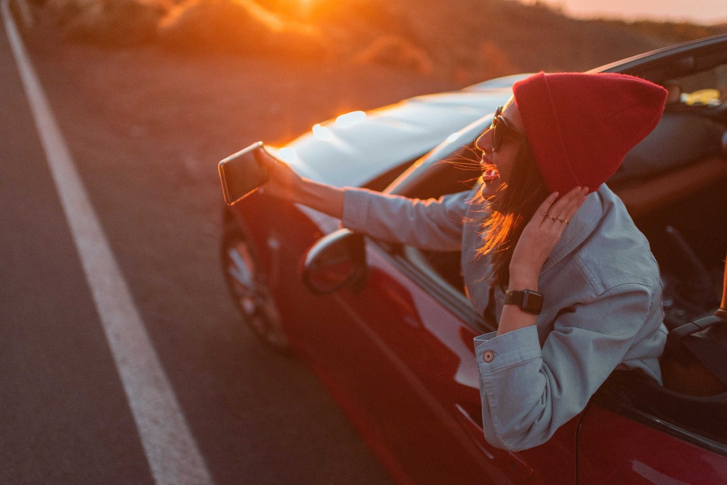 Influencer taking photo with car at sunset