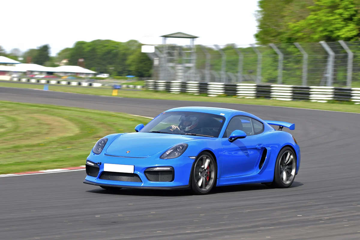 Blue Porsche Cayman GT4 on racetrack