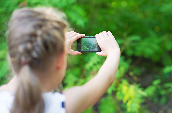 Young girl taking photo on digital camera