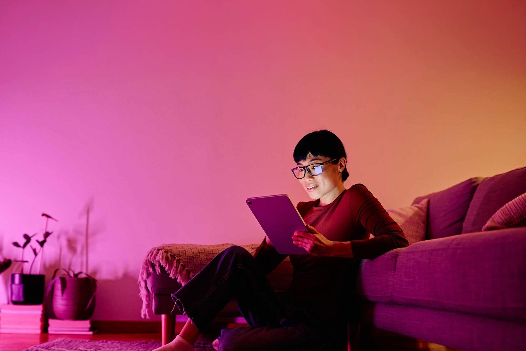 A person by the sofa reading from their tablet