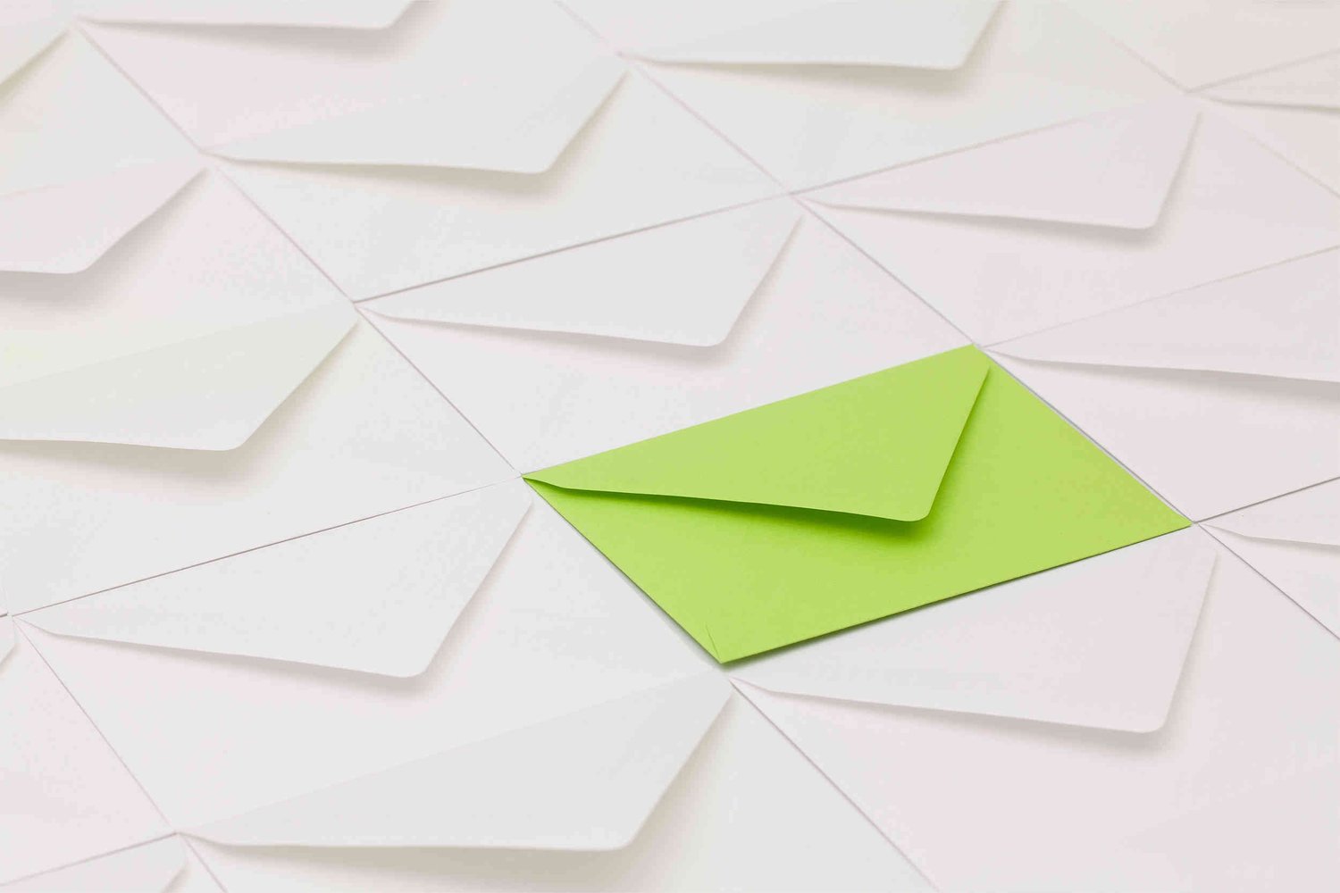 Green envelope amongst other white envelopes