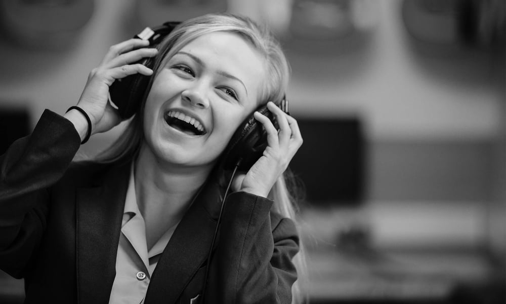 School girl in music class wearing headphones