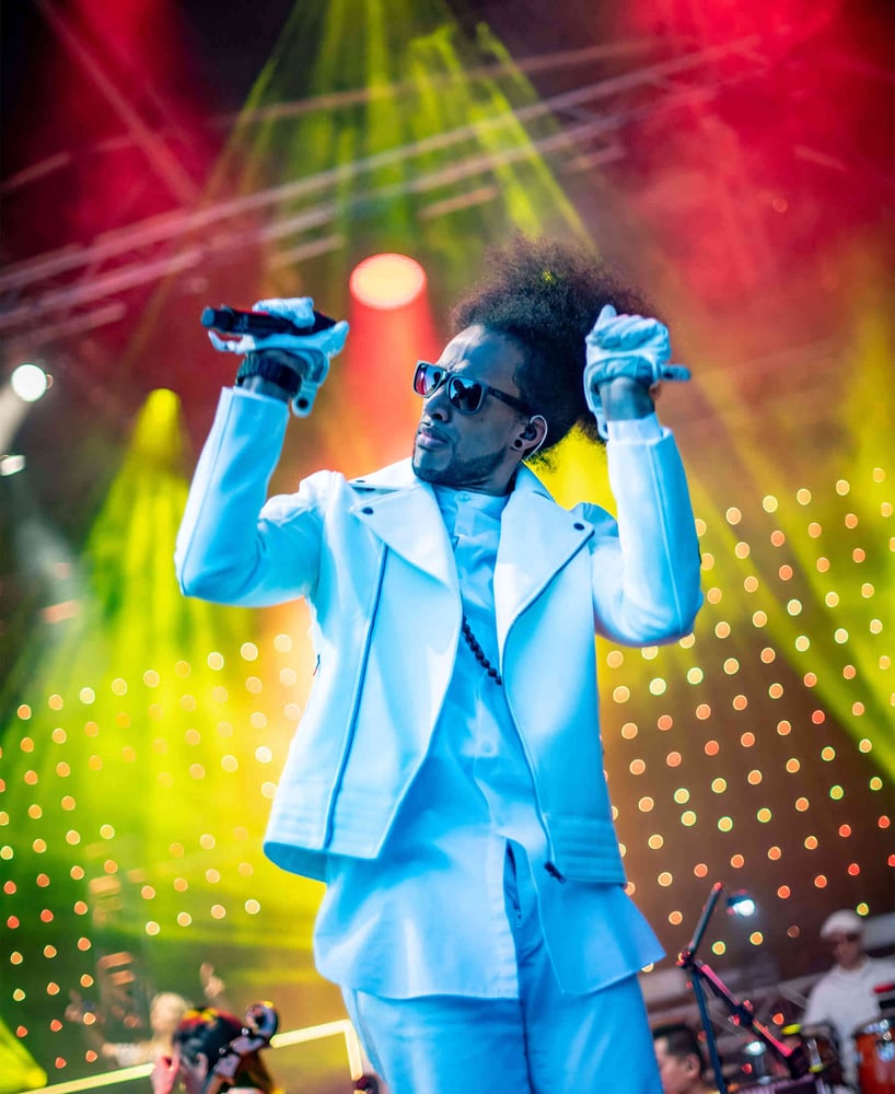 Male singer on stage with vibrant strobe lights behind