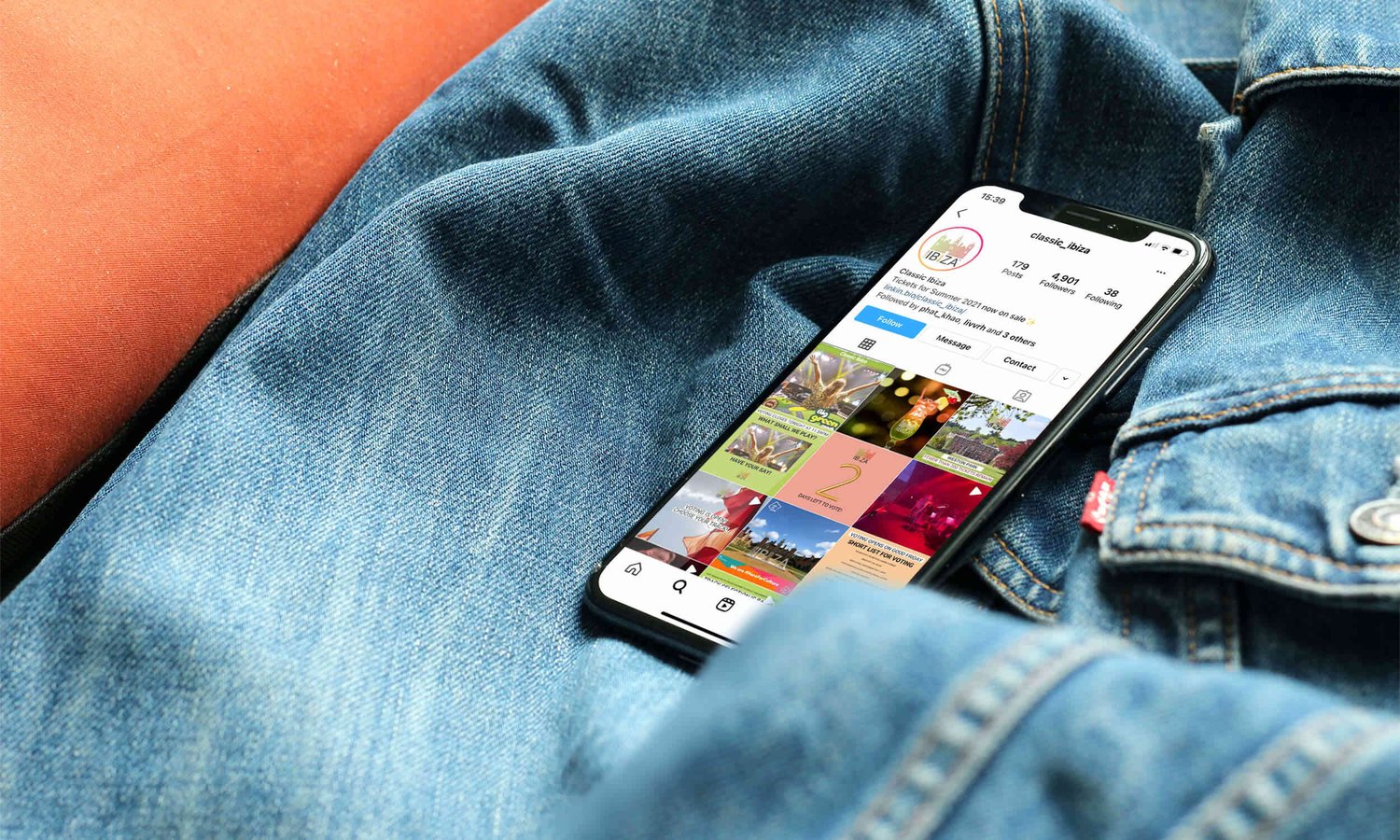 Smartphone on denim jacket displaying the instagram feed for Classic Ibiza