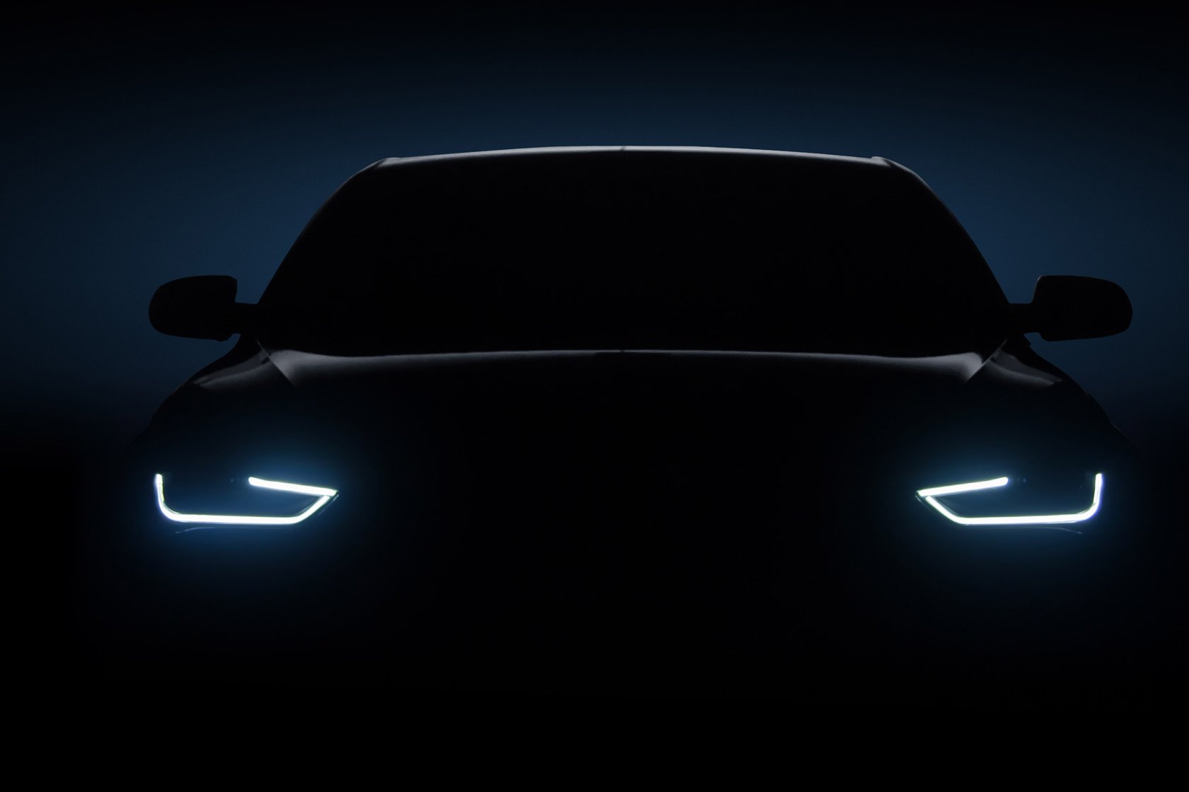 A car front view in the dark with headlights on.